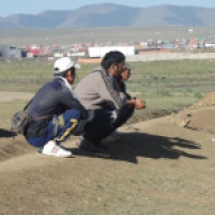 Mongolians squatting by road